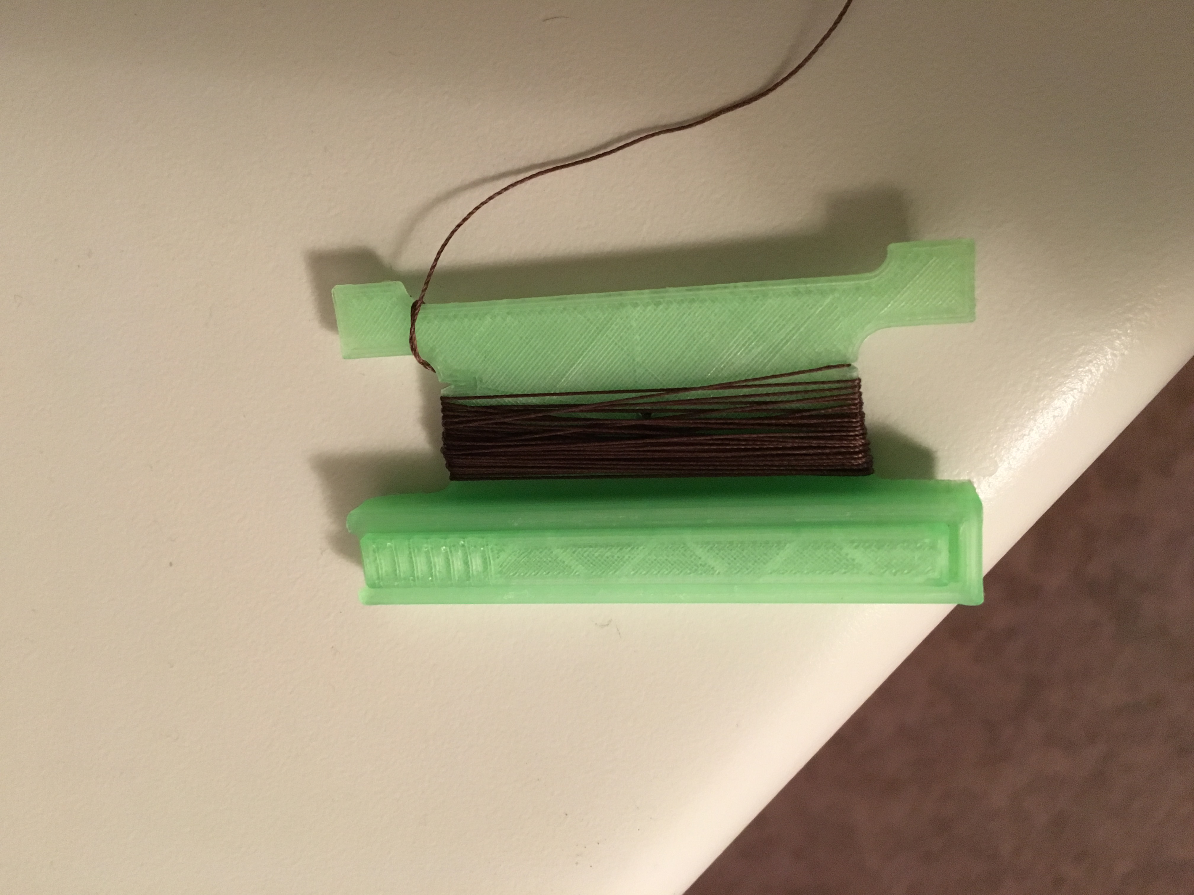 Emergency sewing kit spool with needle storage compartment